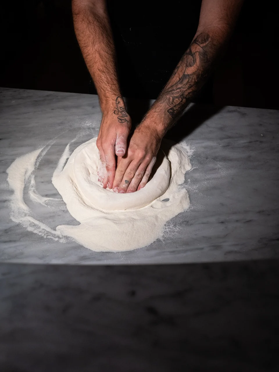 Our pizzaioli shaping the dough by hand